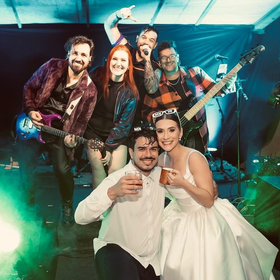 Banda e noivos brindando no palco